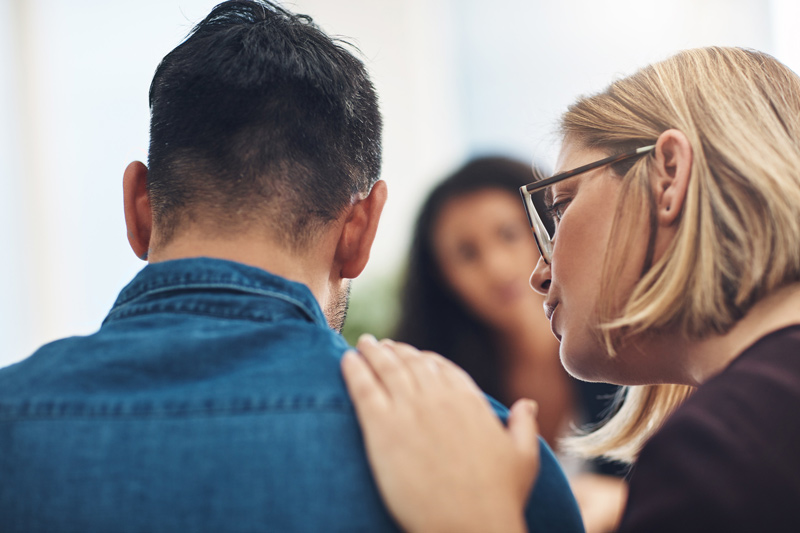 Mujer que trata de apoyar en el duelo a un compañero de trabajo Mujer que trata de apoyar en el duelo a un compañero de trabajo