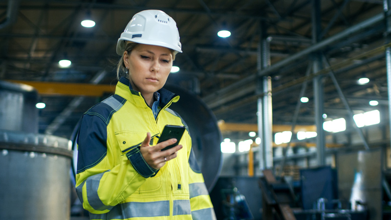Un trabajador que usa un teléfono móvil en el trabajo.